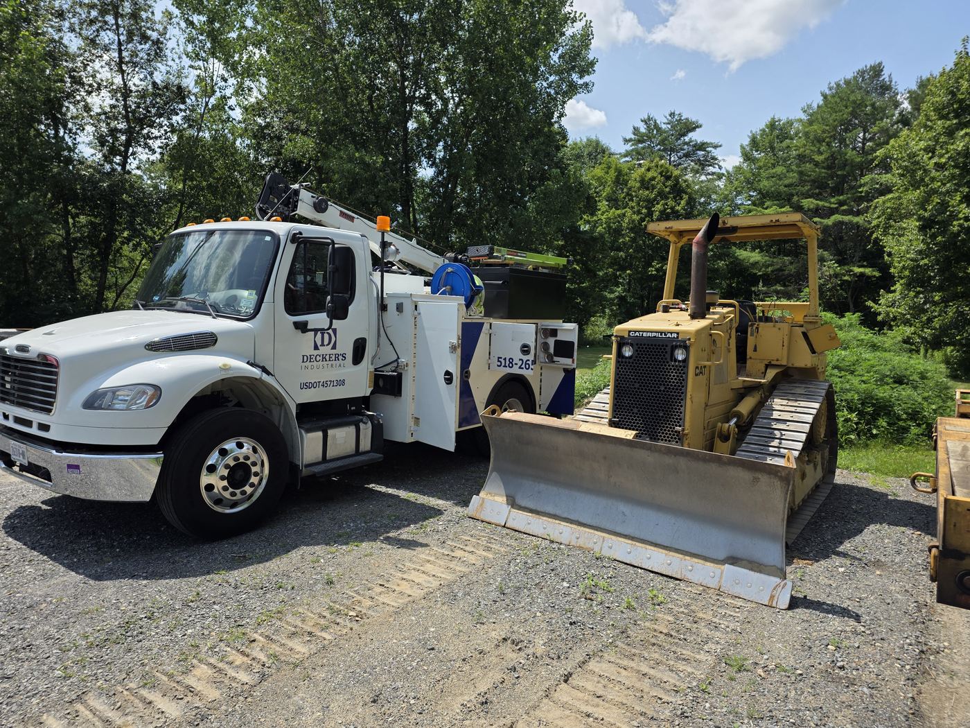 Decker's Industrial service truck alongside a CAT dozer on a gravel site during a service call